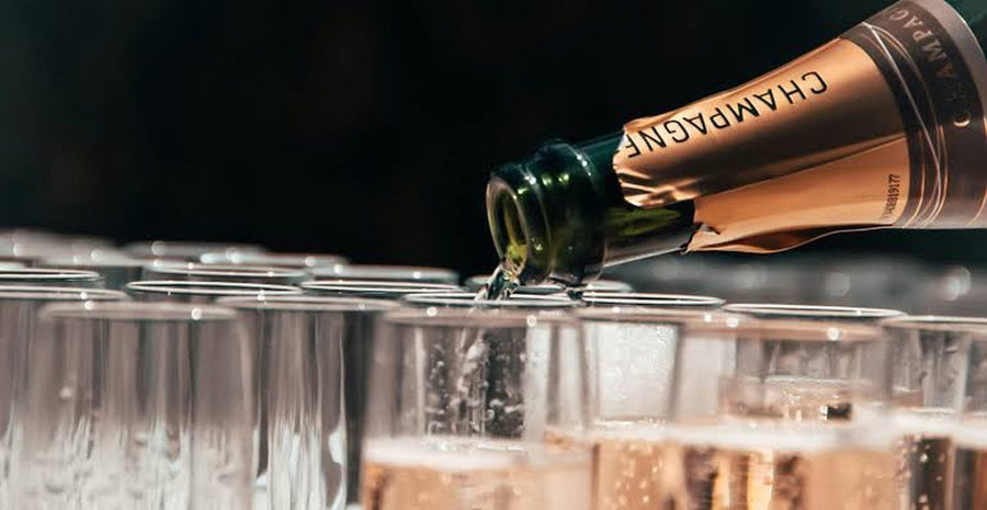 Champagne being poured into rows of flutes